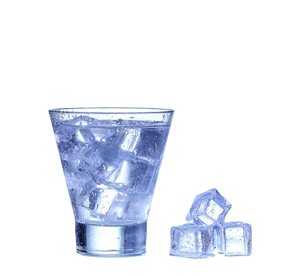 Glass of water, ice and slice of fresh lemon on a white wall