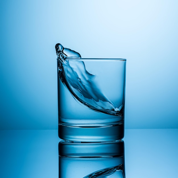 A glass of water is splashing a wave. Taken in Studio with a 5D mark III.