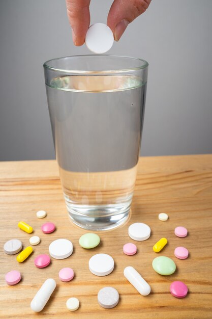 The Glass of water and medicine capsule on white background.