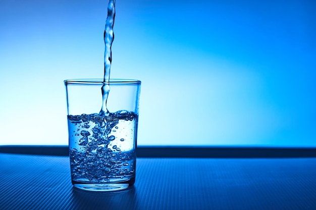 Foto un bicchiere d'acqua che spruzza sul tavolo.