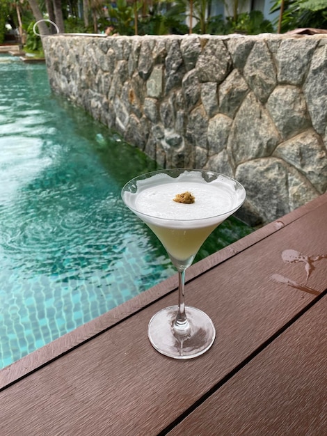 Foto un bicchiere d'acqua sul tavolo vicino alla piscina