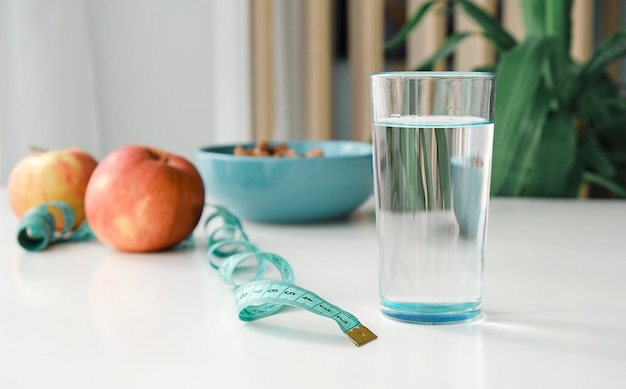 Bicchiere d'acqua sul tavolo mangiare pulito ed esercizio fisico per un concetto di buona salute