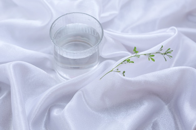 Glass of water on a white fabric