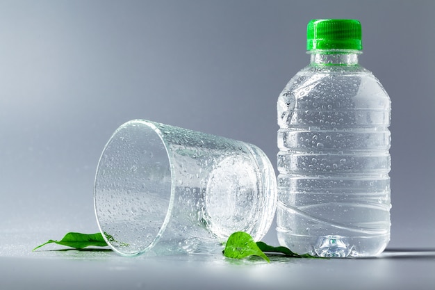 Glass of water with a bottle on table