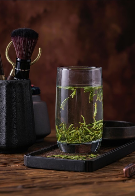 A glass of water with a brush in it and a brush on the side.