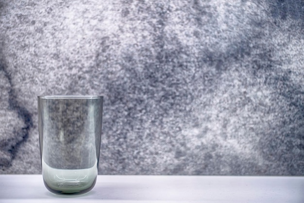 A glass of water with a gray background