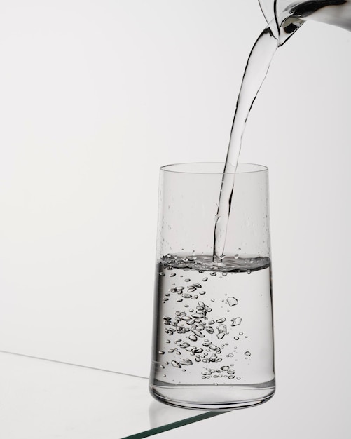 Glass of water with ice on a glass table