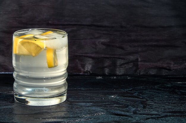 A glass of water with lemon and ice