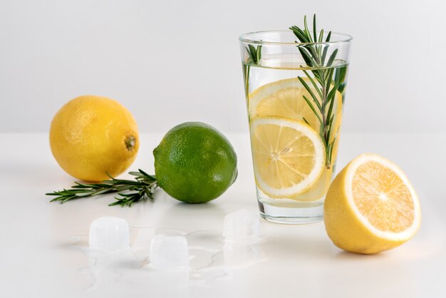 The glass of water with lemon slices, rosemary and ice.