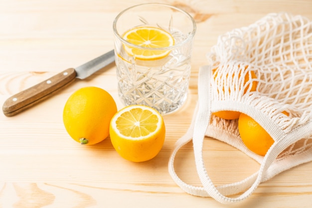 Glass of water with lemon on a wooden table, morning drink for a healthy lifestyle