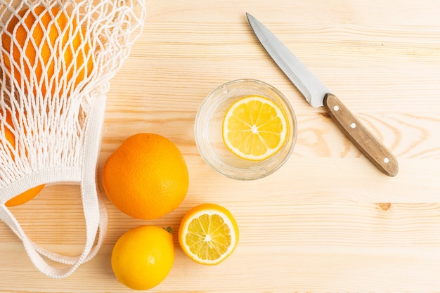 Bicchiere d'acqua con limone su un tavolo di legno, bevanda mattutina per uno stile di vita sano