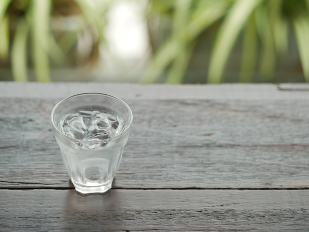 木製のテーブル上の水のガラス