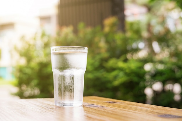 A glass of water on a wooden table.