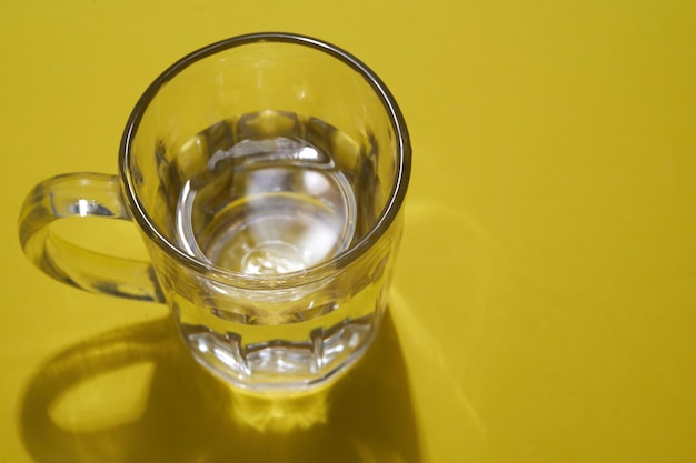 Glass of water on the yellow background