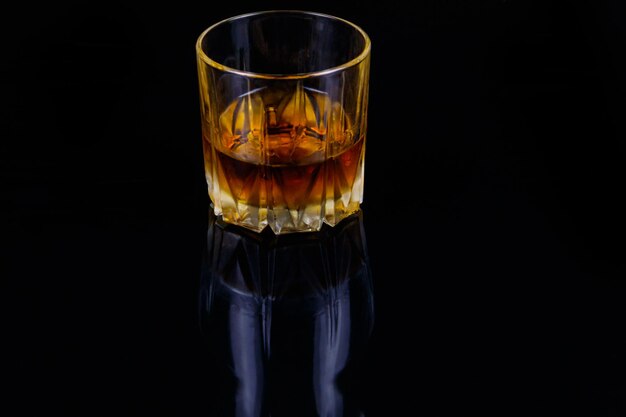 Glass of whiskey on a black background