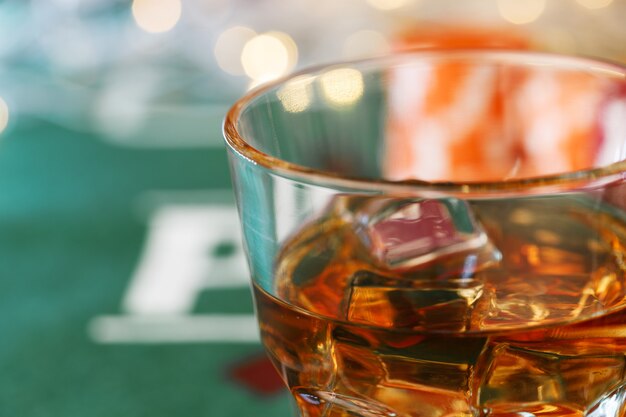 Glass of whiskey on casino table close up