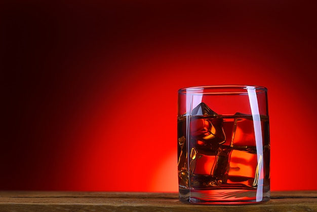 A glass of whiskey or cognac and ice cubes.