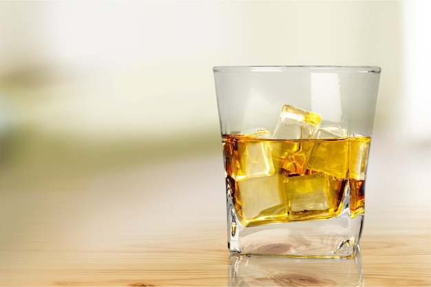 Glass of whiskey and ice isolated on background