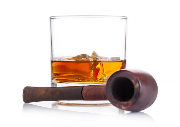 Bicchiere di whisky con cubetti di ghiaccio e tubo di fumo vintage