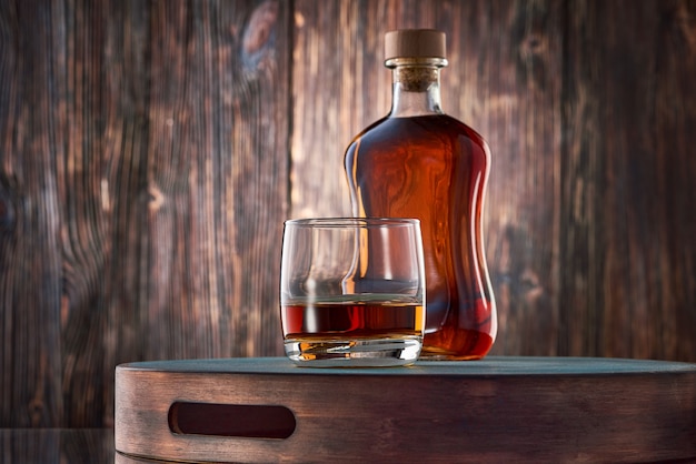 Glass of whisky and a bottle on the wooden table