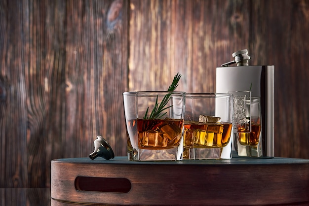 Glass of whisky and a flask on the wooden table