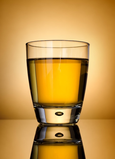 Glass of whisky on a gold background