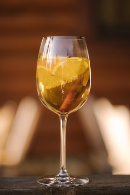 나무 테이블에 레몬 한 조각을 넣은 화이트 드라이 와인 한 잔