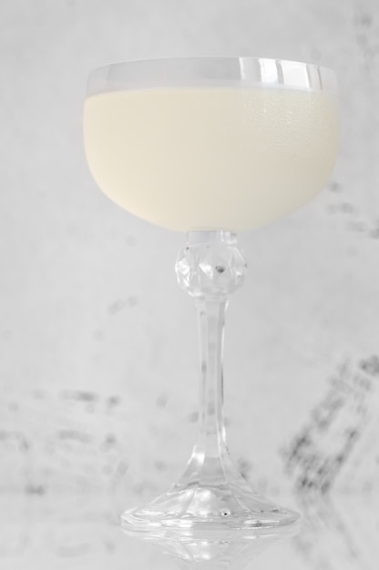 A glass of White Lady Cocktail on white surface