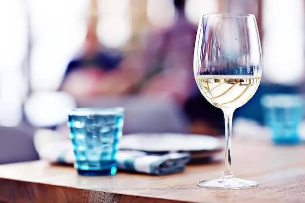 glass of white wine in the restaurant / white wine in the interior of the restaurant a table with glasses of wine, a romantic summer