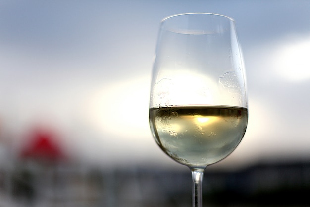 Glass of white wine on the sky background