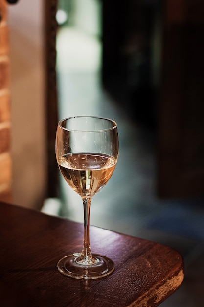 ヴィンテージの木製テーブルに白ワインのグラス