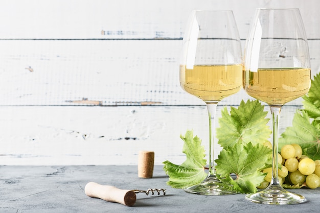 Glass of white wine on vintage wooden table.