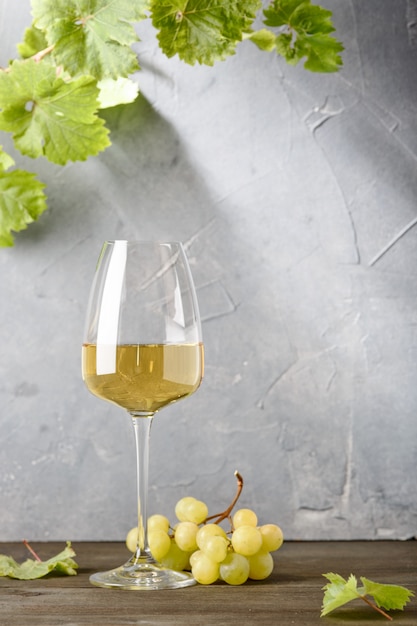 Glass of white wine on vintage wooden table.