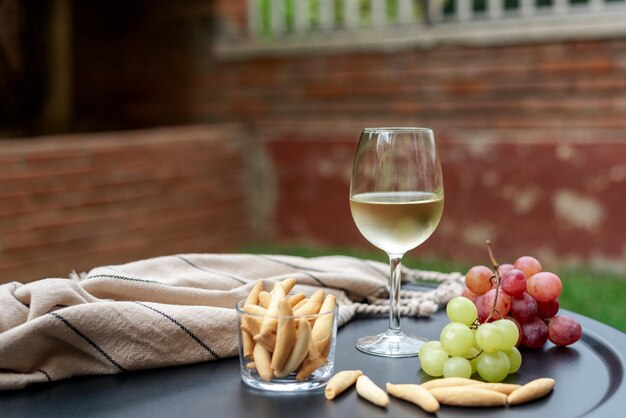 庭のテーブルの上にある白ワインのグラスと前食