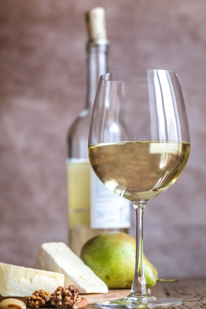 Foto bicchiere di vino bianco con formaggio e noci