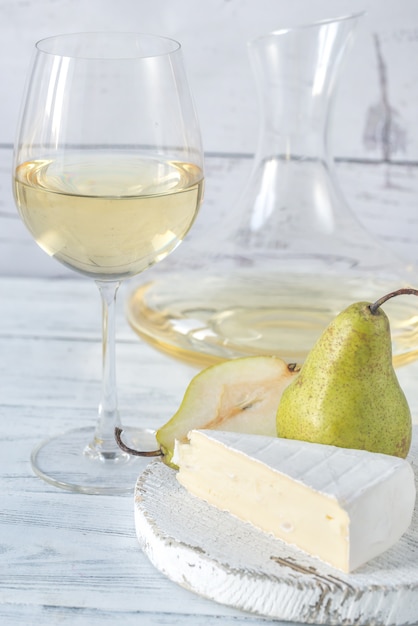 Стакан белого вина с сыром и грушей