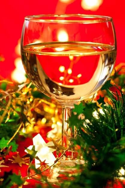 Стакан белого вина с рождественским украшением очень мелкий DOF