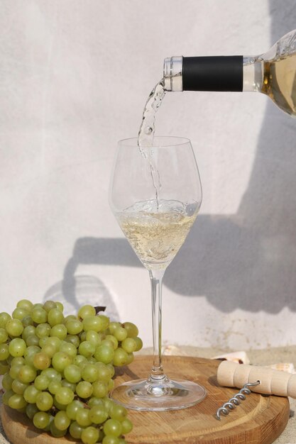 glass of white wine on wooden background with grape