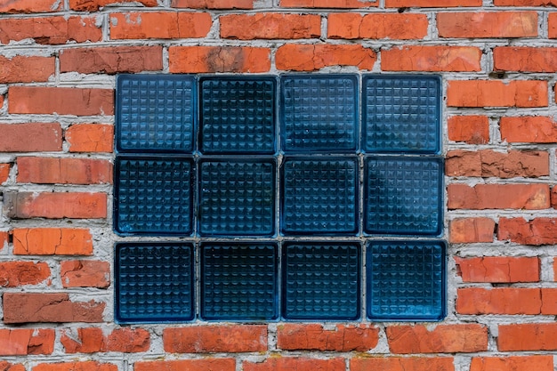 Finestra di vetro in un muro di mattoni rossi