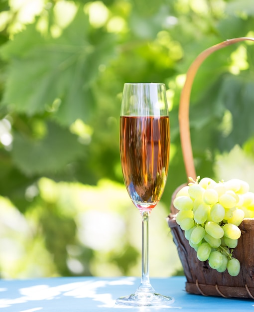 Glass of wine and bunch of grapes in basket