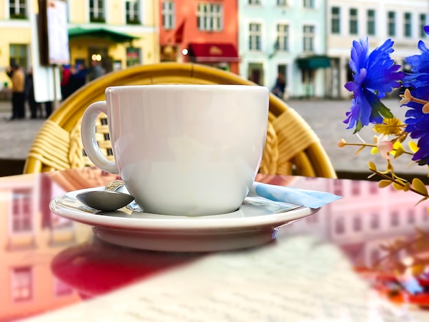 Foto bicchiere di vino e tazza di caffè nella tabella del caffè di strada nella città vecchia di tallinn