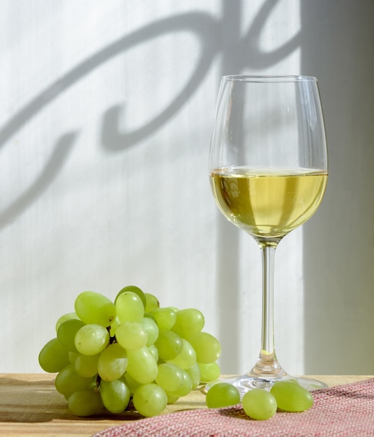 Glass of wine and grapes in the wooden table