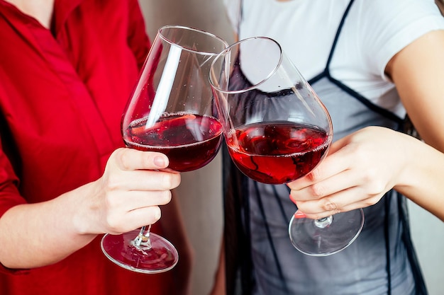 A glass of wine in the hands of two women closeup.