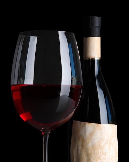 Glass of wine with bottle on bright background