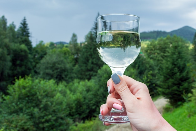 A glass of wine with an inverted image in the girl's hand