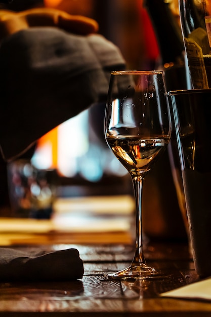 A Glass of wine on the wooden table of the restaurant.