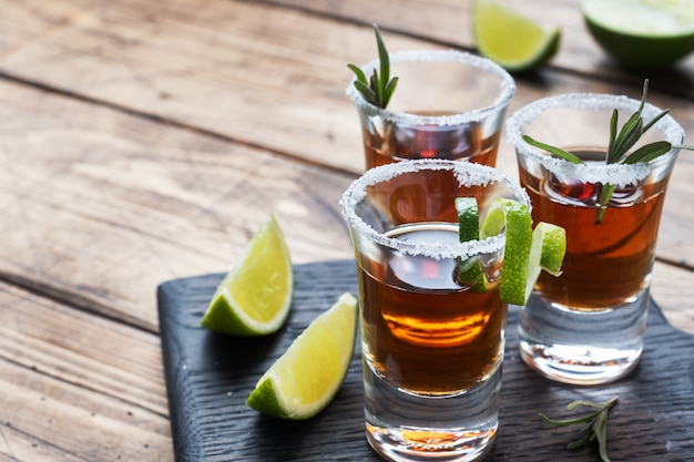 Glass with alcohol, salt and lime on a wooden