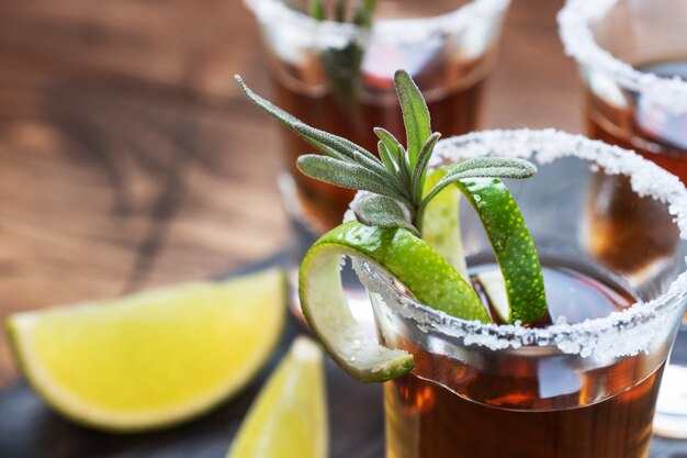 Glass with alcohol, salt and lime on a wooden