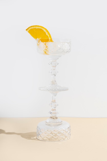 Glass with a cocktail standing on an upturned glass on the table