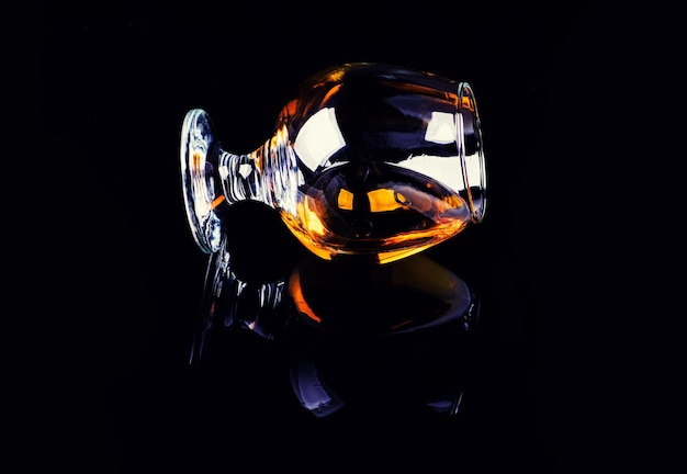 Glass with cognac on a black background